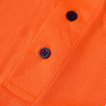 Close-up of a bright orange textured knit polo shirt placket with two dark navy blue buttons.