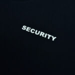 Close-up of the word SECURITY in bold, white, capital letters printed on a black fabric background.