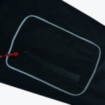 Close-up of a black zippered pocket with reflective piping and a red zipper pull on dark fabric.
