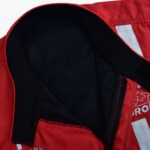 Close-up of a red jacket collar showing the black mesh inner lining and black fabric trim with Velcro fasteners.