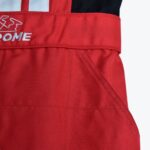 Close-up of a red fabric racing suit showing a waistband with embroidered text, a side pocket, and textured material.