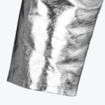 Close-up of a garment sleeve with a shiny, metallic silver and black textured print.