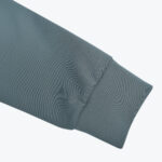 A close-up view of a slate blue sleeve with a ribbed cuff on a white background.