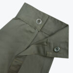 Close-up of an open olive green shirt cuff showing two silver metal snap buttons on a plain white background.