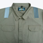 Close-up of a khaki workwear shirt with two chest pockets and reflective silver strips on the shoulders.