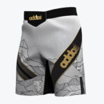 A pair of white and black athletic fight shorts featuring a stylized mountain line art pattern on the lower section and a diagonal black stripe with the gold addos logo.