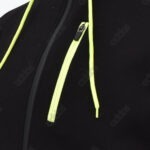 Close-up of a black Addos hoodie showing a neon green drawstring and a neon green lined zipper pocket against a black fabric.