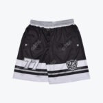 A pair of black athletic shorts with white stripes, featuring the number 77 on one leg and a skull logo on the other.