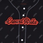 Close-up of a black baseball jersey with CrowdStrike embroidered in black script with a thick red outline.