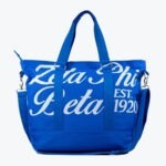 A royal blue tote bag featuring the white text Zeta Phi Beta and EST. 1920 with carrying handles and a shoulder strap.
