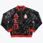 A black sequined bomber jacket with red trim, featuring the Greek letters Delta, Sigma, and Theta in red sequins on the right side and the organization's crest on the left chest.