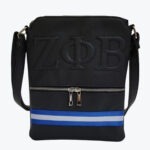 A black pebbled faux-leather crossbody bag with embossed Greek letters Zeta Phi Beta, a silver zippered pocket, and a blue and white striped band at the bottom.