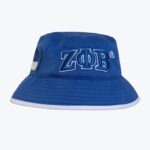 A royal blue bucket hat with the Greek letters ZΦB embroidered on the front in blue and white, featuring a white brim trim.