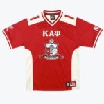 A red short-sleeved jersey featuring white side panels and shoulder accents. The front proudly displays the Greek letters Kappa, Alpha, Psi and the official Kappa Alpha Psi crest.