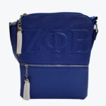 A royal blue pebbled leather crossbody bag with embossed Greek letters Zeta Phi Beta, featuring silver hardware and two hanging white tassels.