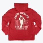 The back view of a red hooded windbreaker jacket with white graphics for Kappa Alpha Psi Fraternity, Inc., showing a silhouette of a man with a cane, the word NUPE, and EST. 1911.