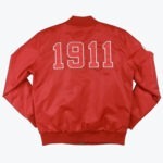 The back of a red bomber-style jacket featuring the year 1911 in large white-outlined numbers.