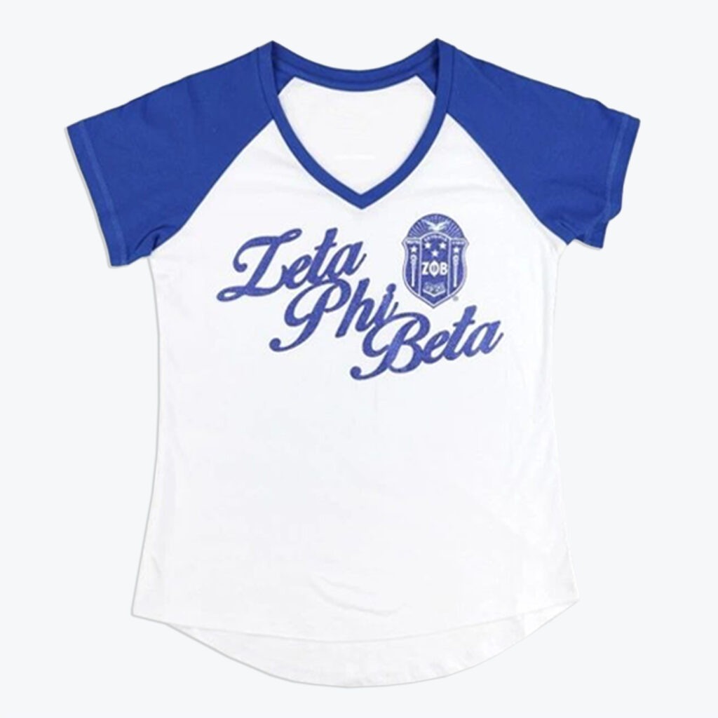 A white and blue raglan V-neck t-shirt with Zeta Phi Beta in blue script and the sorority's crest printed on the chest.