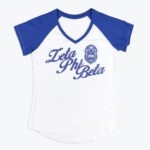 A white and blue raglan V-neck t-shirt with Zeta Phi Beta in blue script and the sorority's crest printed on the chest.