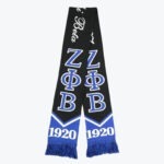 A black and blue knit scarf with the Greek letters for Zeta Phi Beta, the text Zeta Beta in script, and the year 1920 at the fringed bottom.
