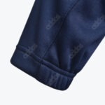 Close-up of a dark blue Addos sleeve cuff showing the stitched seam and subtle repeating brand logo pattern on the fabric.