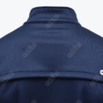Close-up of the upper back of a navy blue Adidas jacket showing a subtle repeating wordmark pattern and a horizontal seam.